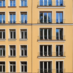 **Latvian Investment Immigration:** A modern apartment building in Riga, Latvia, with families moving in.  Highlight the blend of old and new architecture, with a European feel.